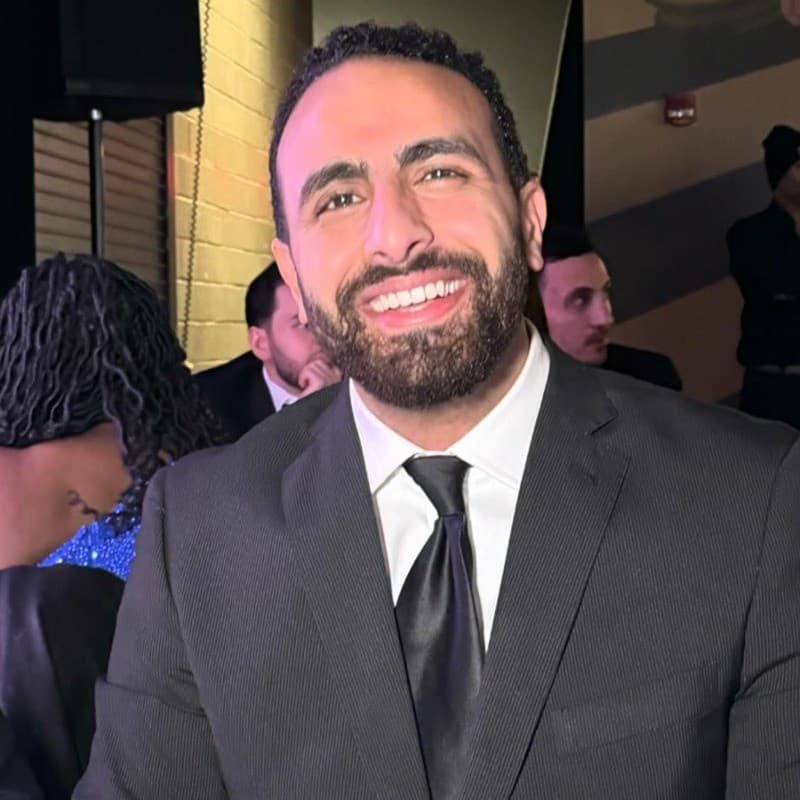 Smiling man in a dark suit and tie